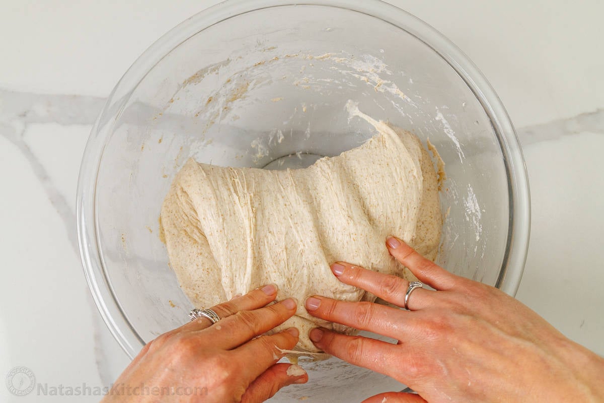 Folding the sourdough bread dough over during the bulk fermentation step of the sourdough bread recipe