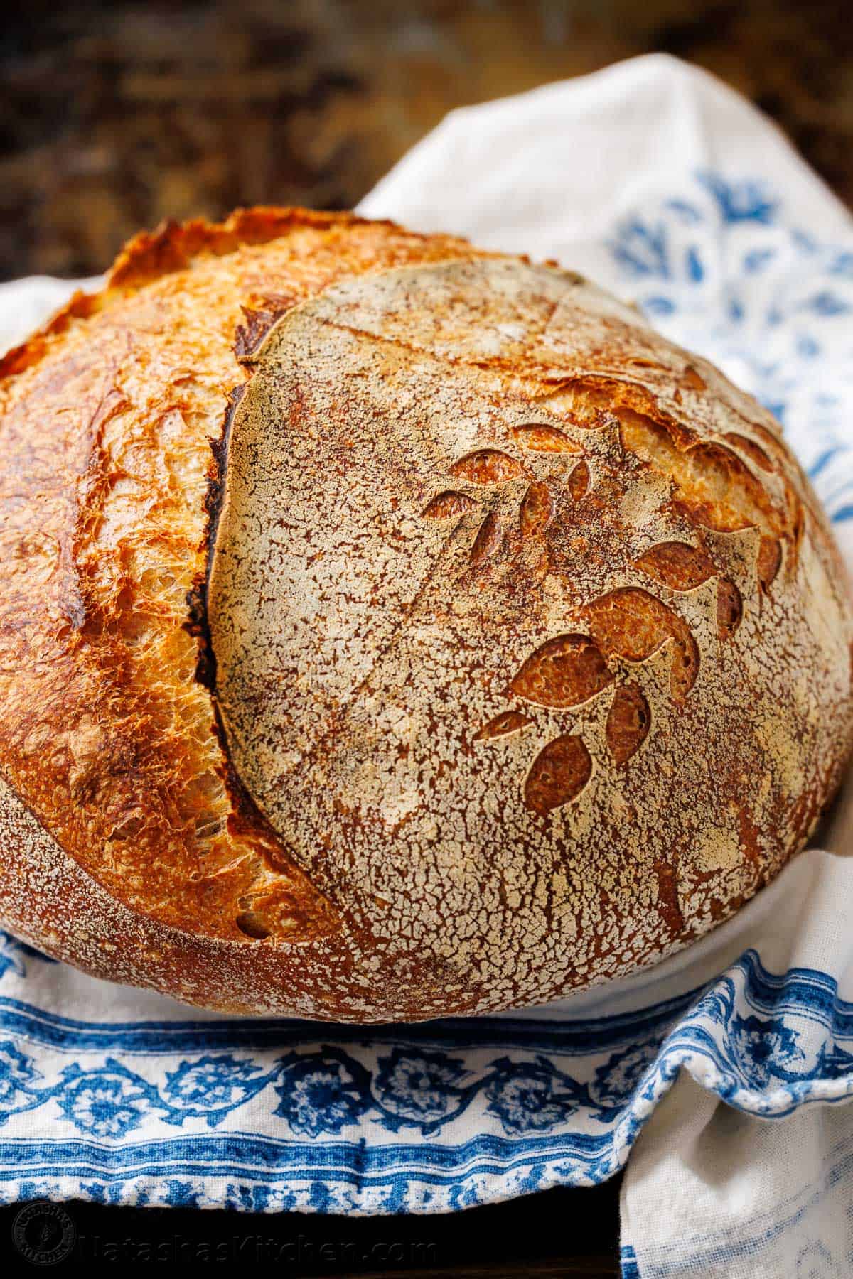 Baked sourdough bread on a blue and white kitchen towel