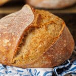 Close up photo of finished sourdough bread on tea towel