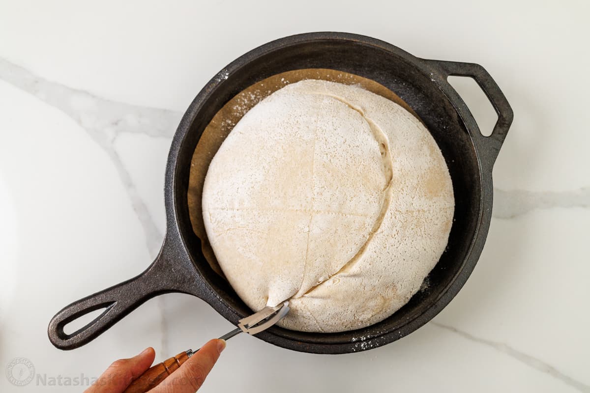 Using a bread lame to score a sourdough bread boule