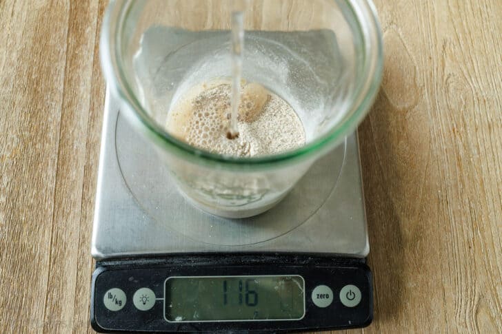 Pouring water into flour in glass jar