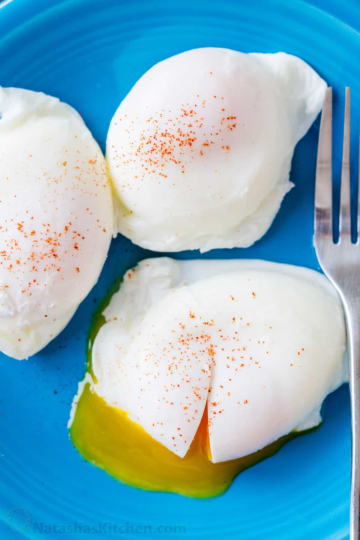 Perfectly cooked poached eggs on a plate with fork