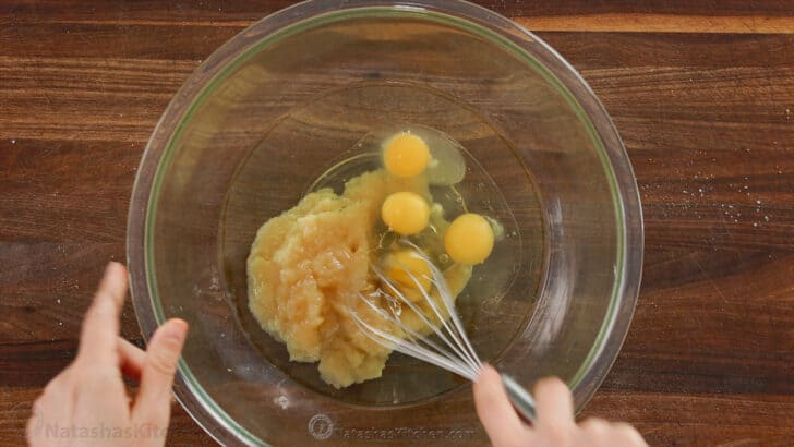 Whisking eggs and apple sauce in a bowl with oil