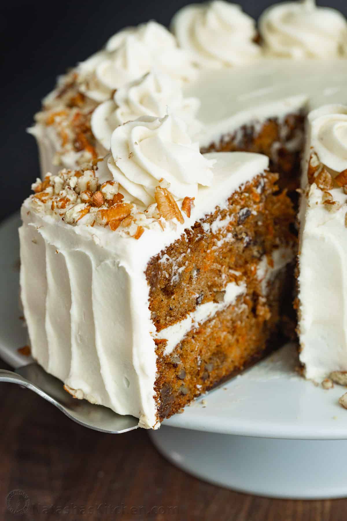 slice of carrot cake pulled out of the whole cake