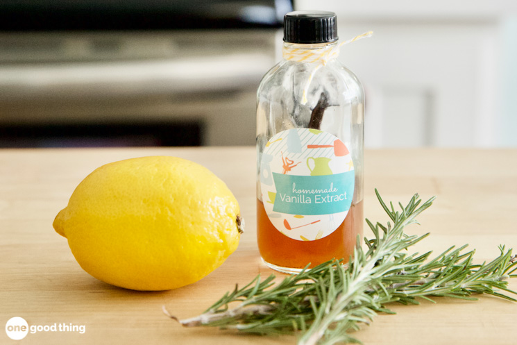 lemon, rosemary, and a jar of vanilla extract sitting on a butcher block kitchen counter