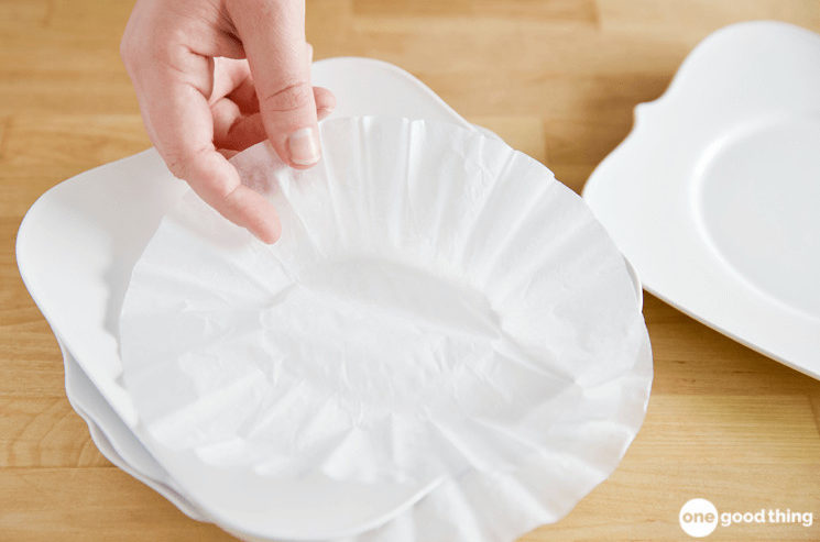 Put a coffee filter between plates to keep them from scratching each other.