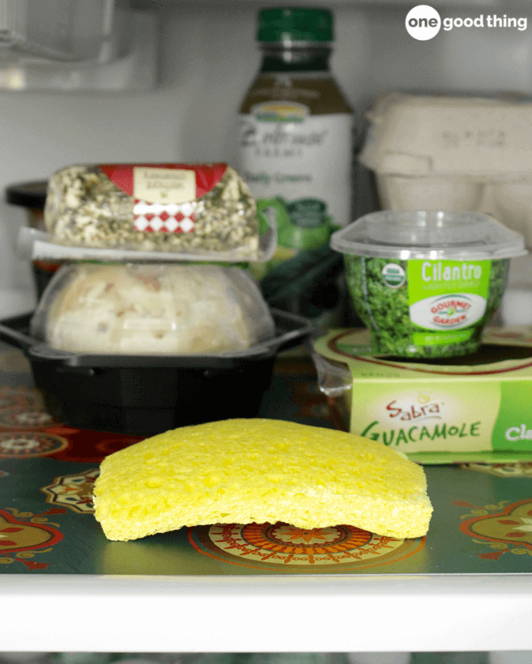 yellow sponge sitting on a shelf in a fridge surrounded by various foods