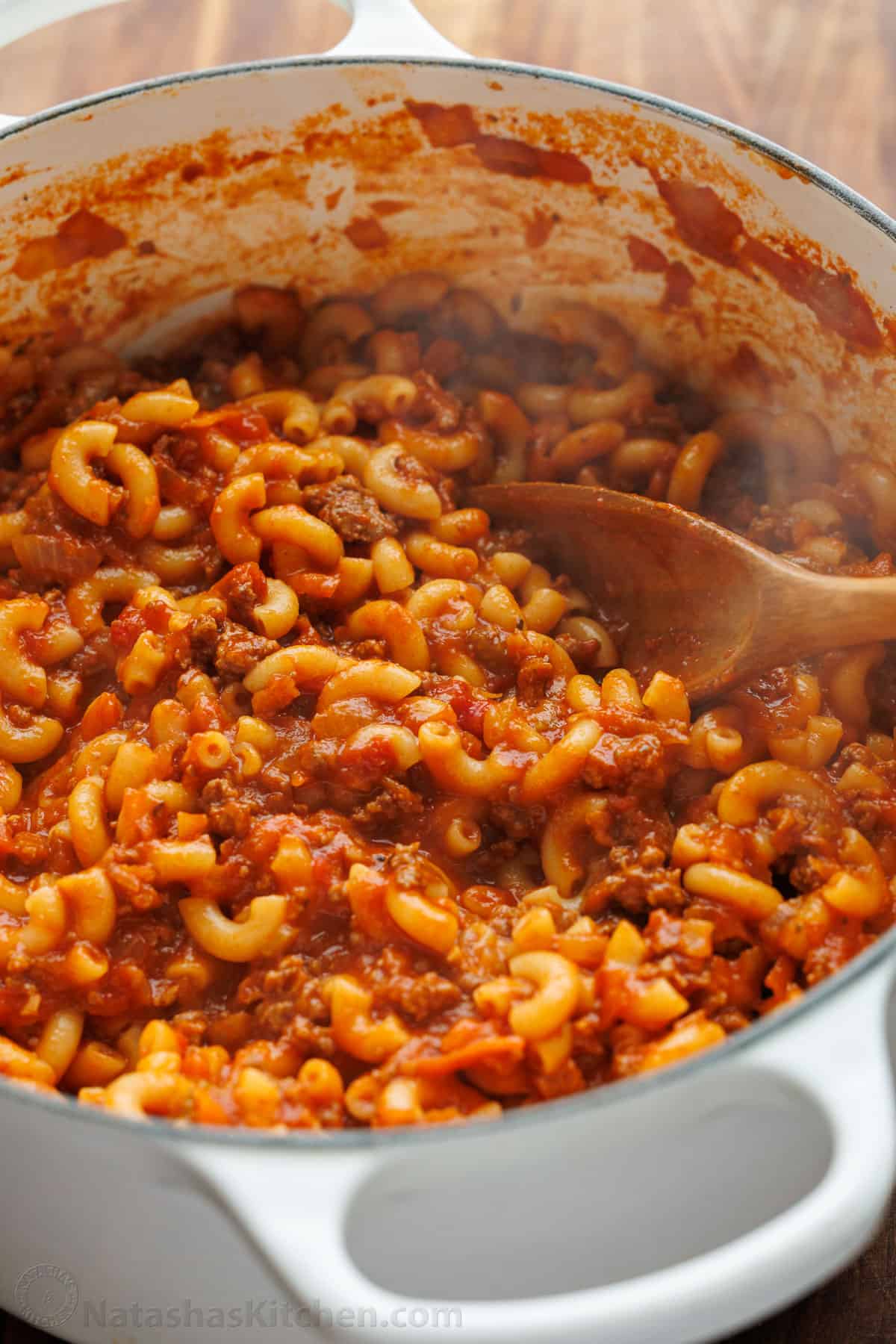 Dutch oven filled with American Goulash with ground beef, tomatoes and elbow macaroni pasta