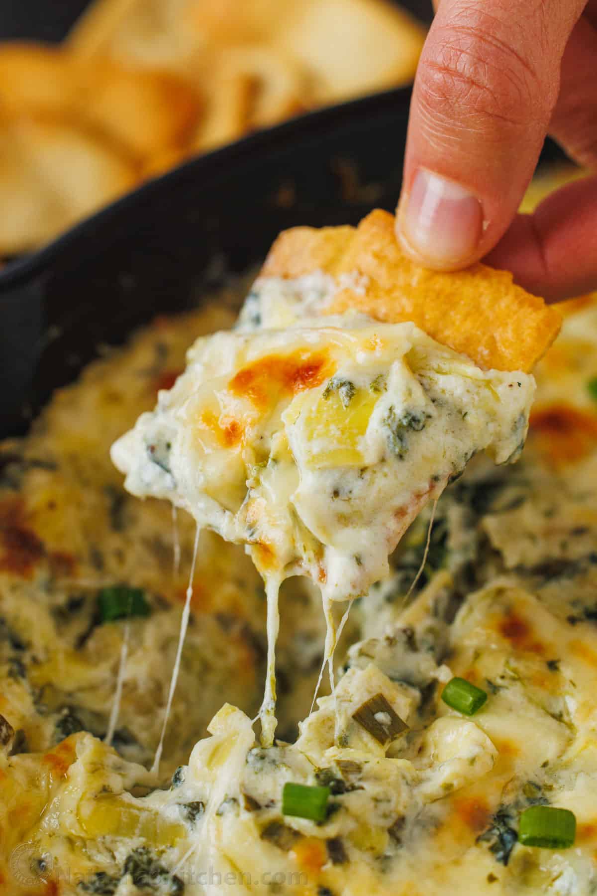 A must-try Baked Cheesy Spinach and Artichoke Dip - This one-dish recipe is delicious, so easy to assemble, and is the perfect party food.