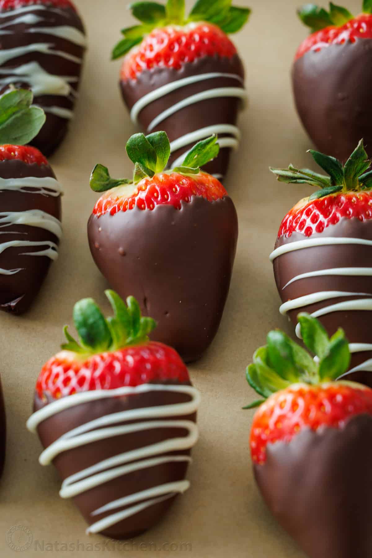 Homemade chocolate covered strawberries resting on a baking sheet